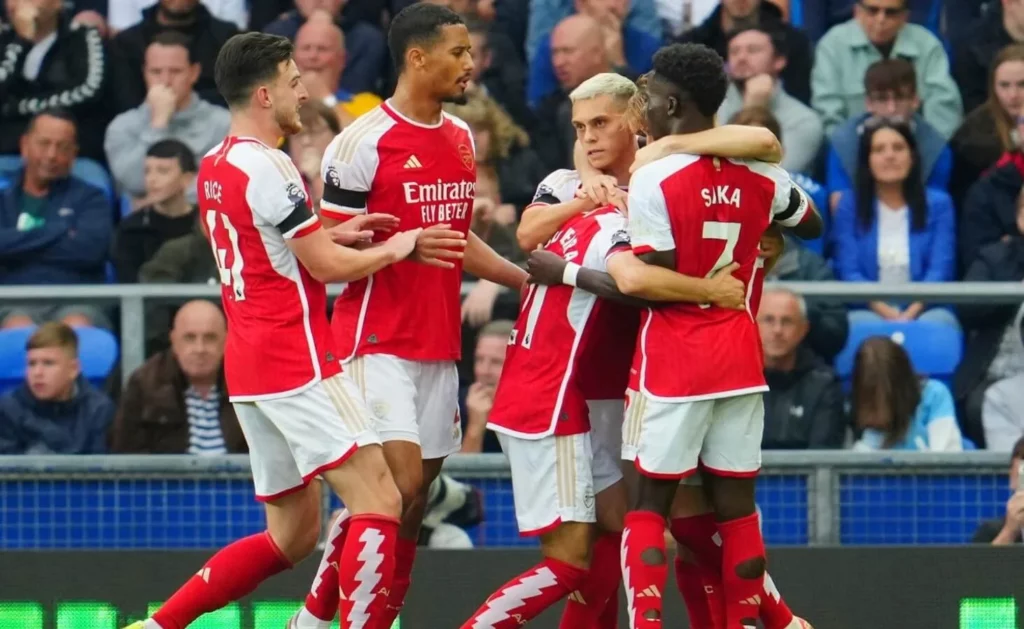 Joyous Arsenal footballers embracing after a successful goal.