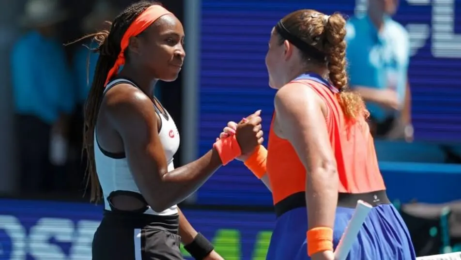 Coco Gauff and Jelena Ostapenko greeting each other on court.