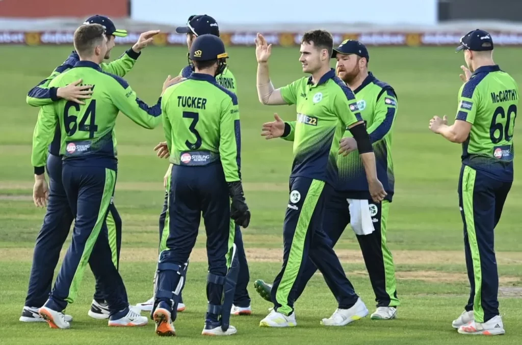 Close-up of Irish cricket players interacting during a break in play.