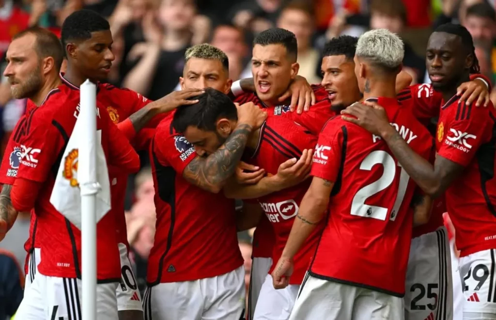 Manchester United players celebrating a scored goal with joy and enthusiasm.