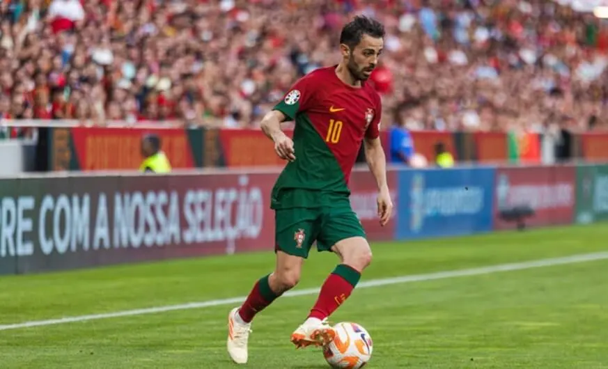 Portuguese soccer player in action on the field.