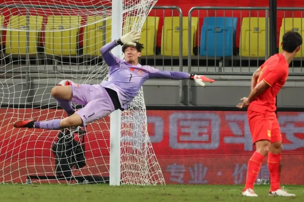 Yan Junling trying to stop Krouma's shot against Syria.