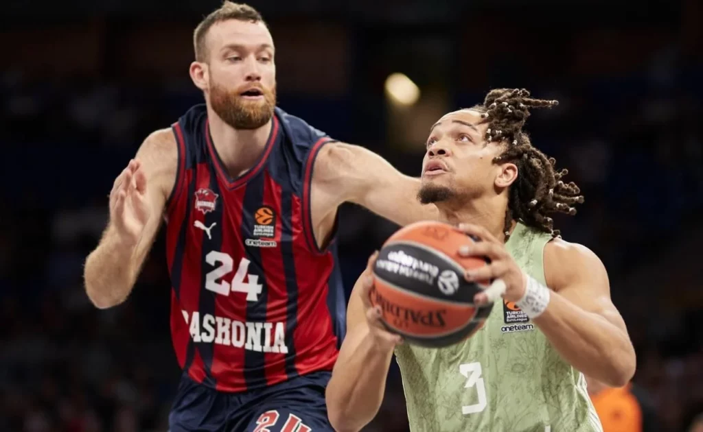 Intense defense by a Baskonia player during gameplay.