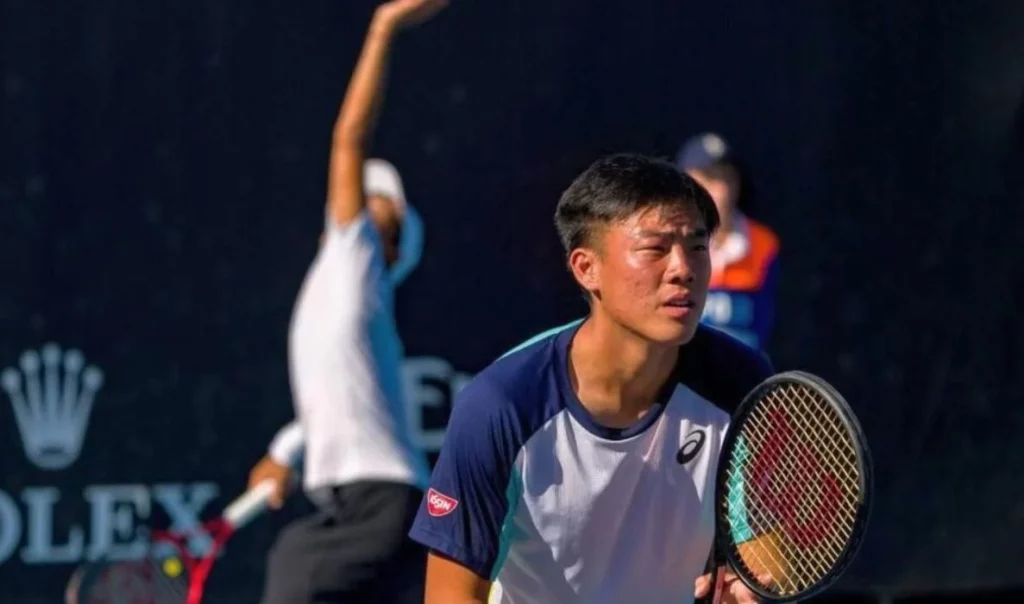 Chak Lam intensely focused during a tennis game.