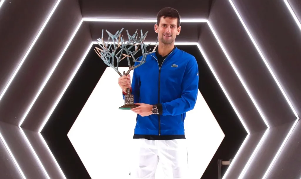 Novak Djokovic holding the Rolex Paris Masters trophy.