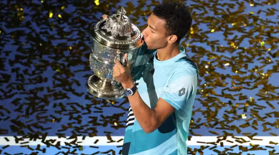 Felix Auger-Aliassime proudly holding his Basel title trophy.