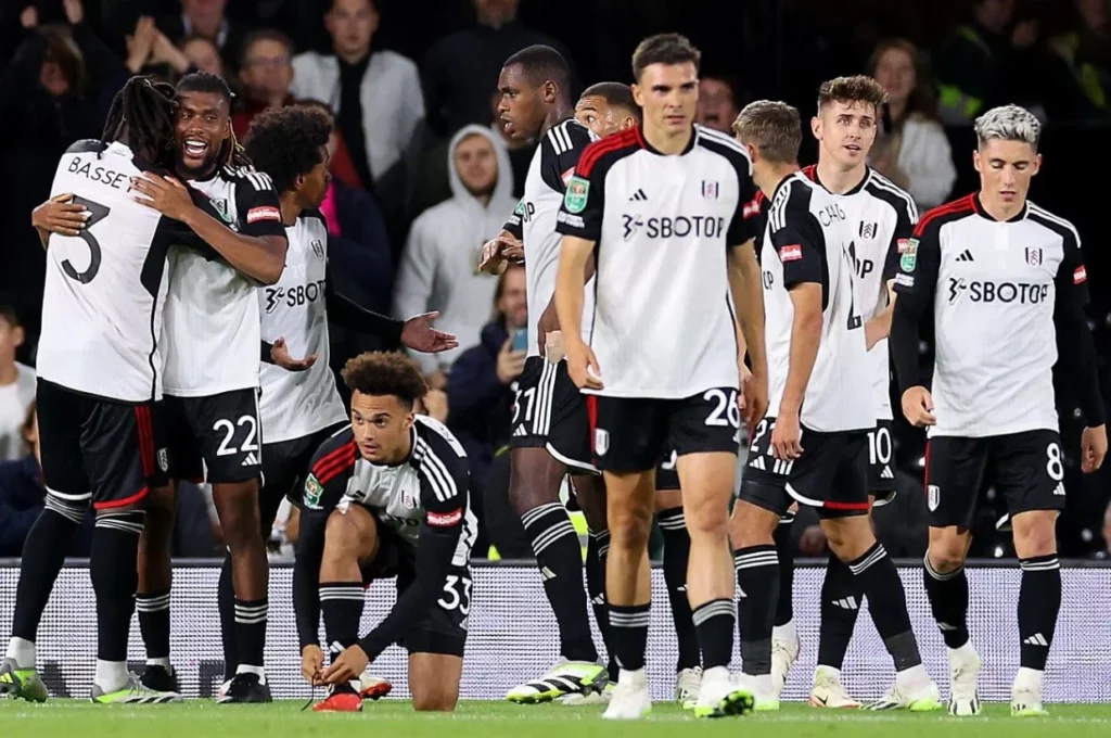 Fulham players sharing a celebratory moment after scoring a goal.