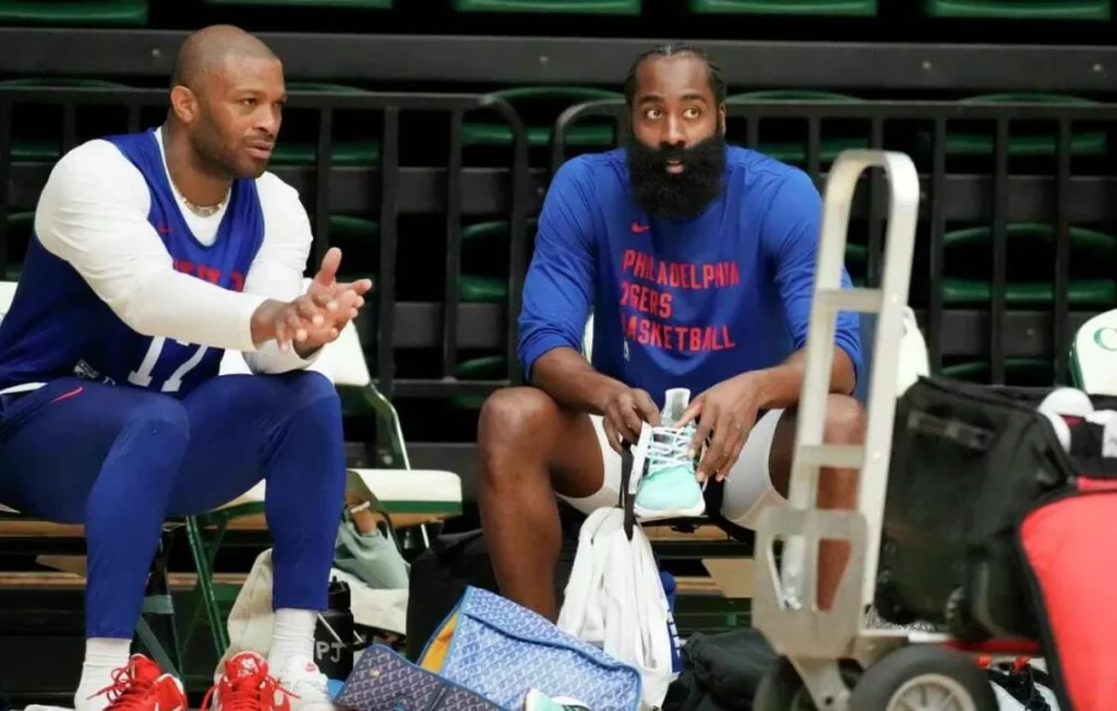 P.J. Tucker converses with teammate James Harden at a 76ers' training session.