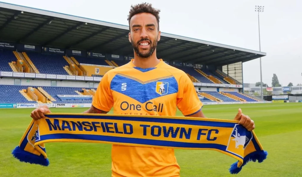 Mansfield player posing with the club's signature scarf after the match.