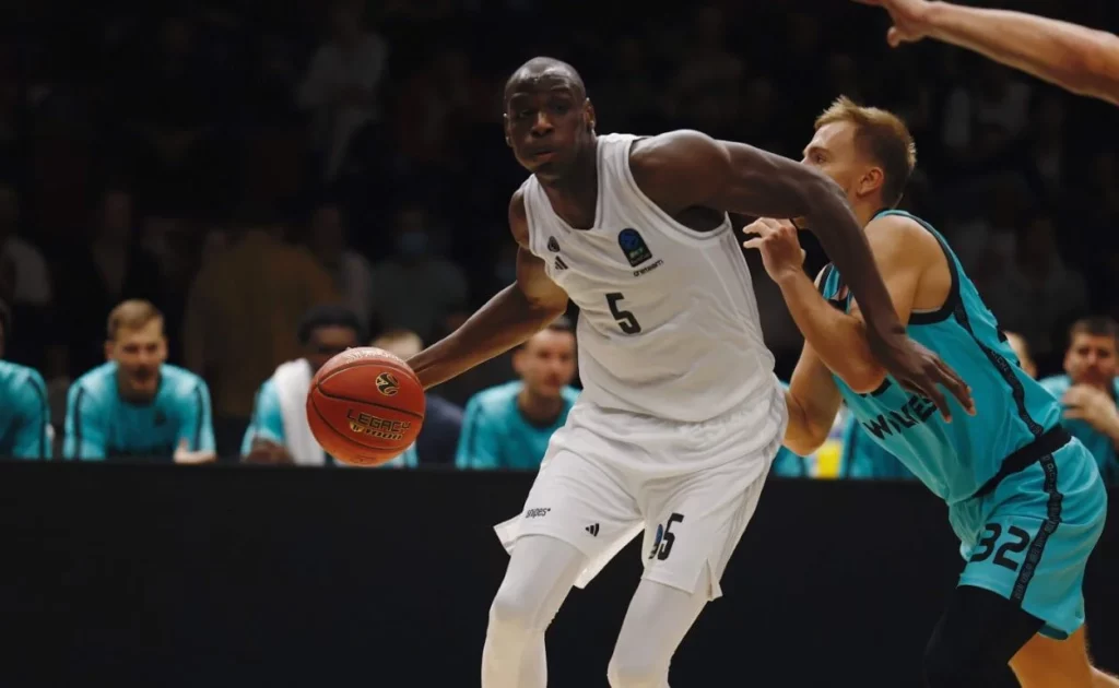 Paris Basketball player skillfully dribbling the ball.