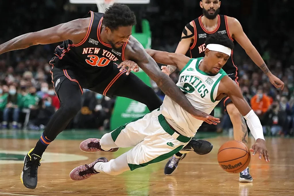 Fierce ball battle between Celtics and New York players on the court.