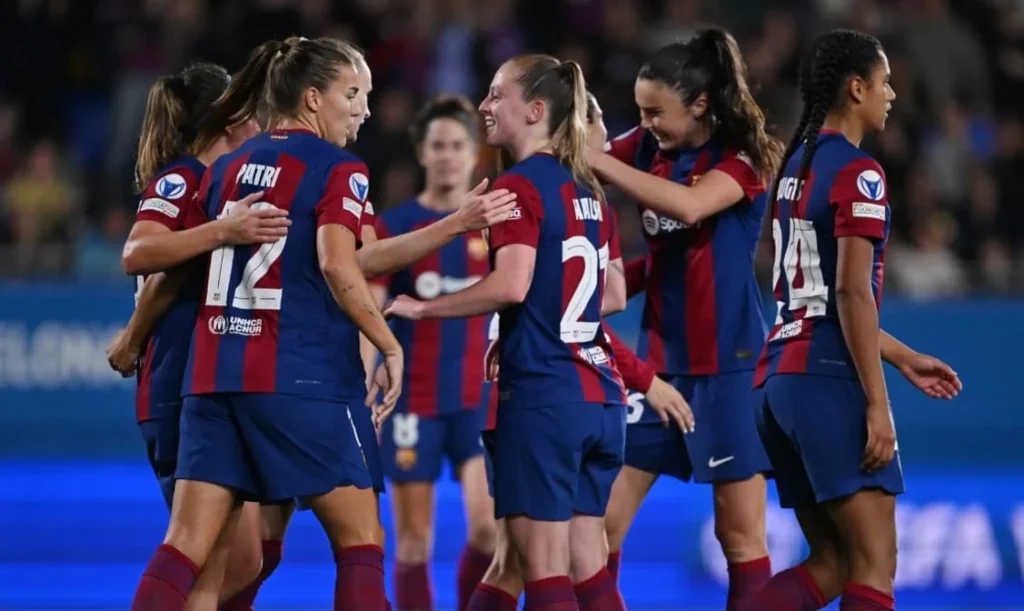 Barcelona women's soccer team rejoicing together after a goal.