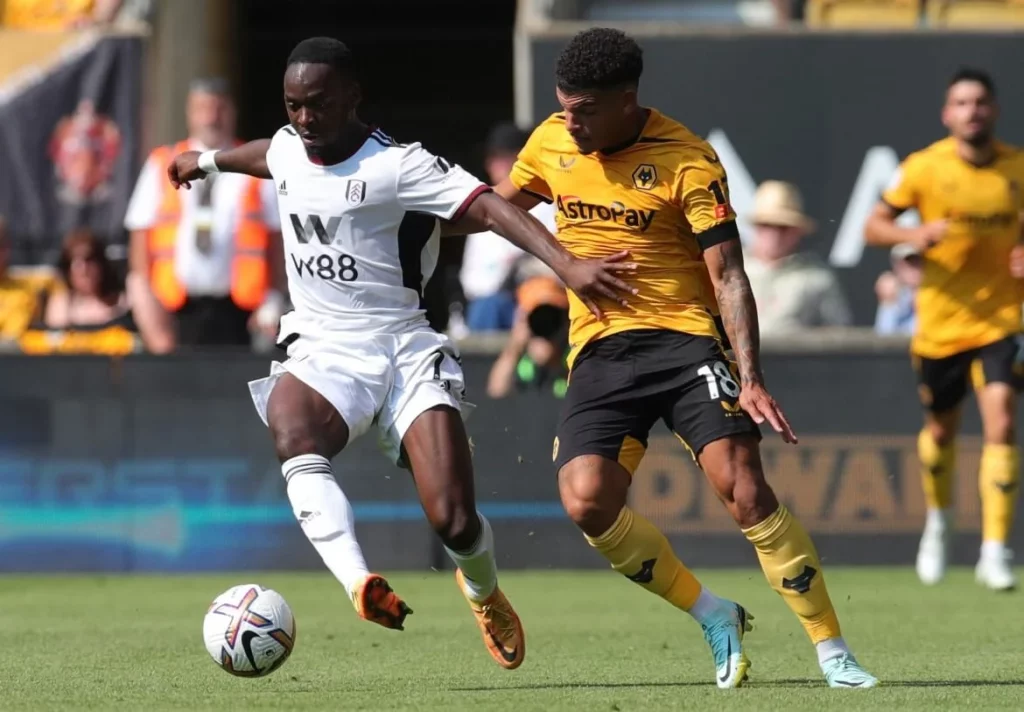 Premier League clash scene with Fulham and Wolverhampton players in action.
