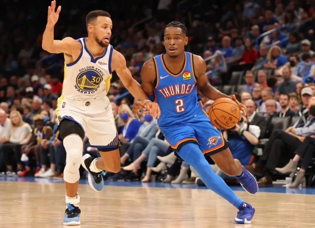 Players in motion during the Warriors vs Thunder NBA matchup.