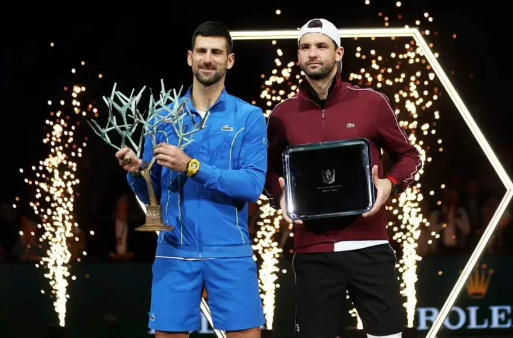Novak Djokovic holding his Paris Masters trophy beside runner-up Grigor Dimitrov at the award ceremony.