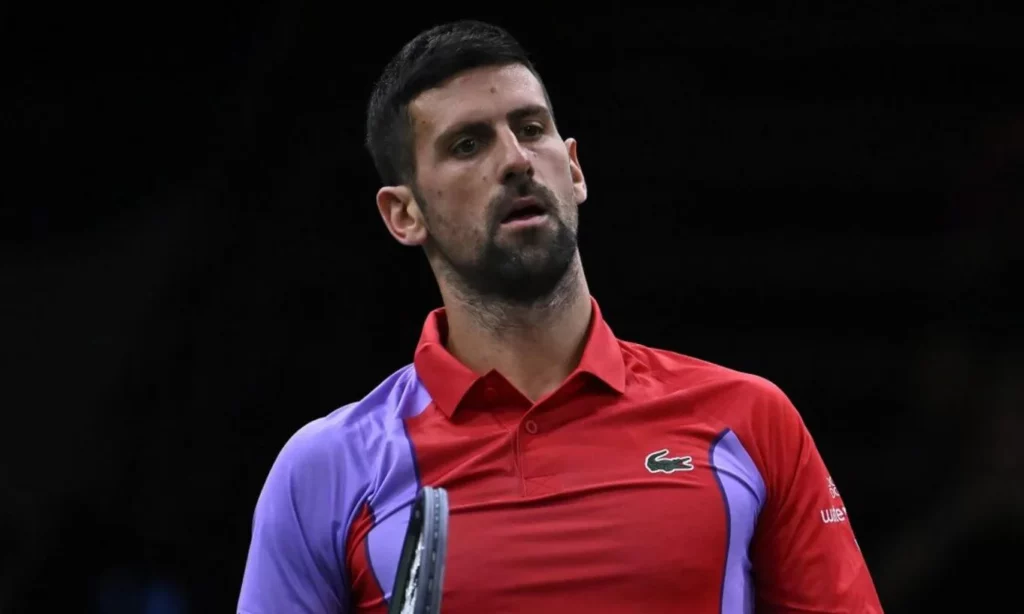 Novak Djokovic with a contemplative expression during a match pause.