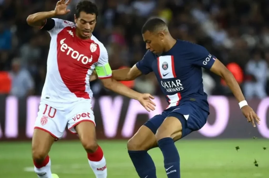 Intense match moment between PSG and Monaco players in Ligue 1 game.