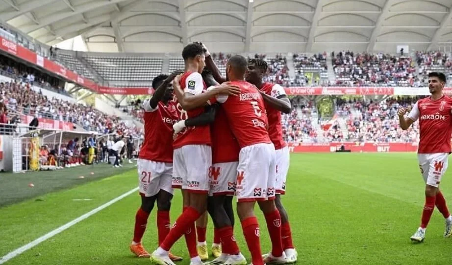 Goal celebration by Reims players on the field.