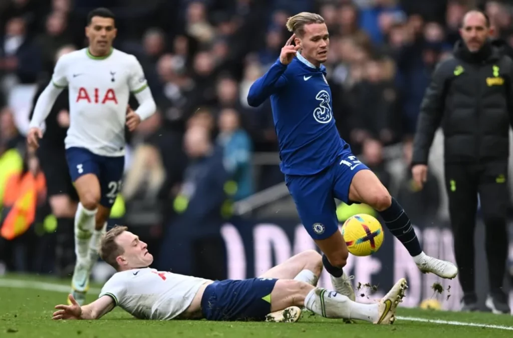 Tottenham defender clears the ball from under Mudryk with a slide tackle.