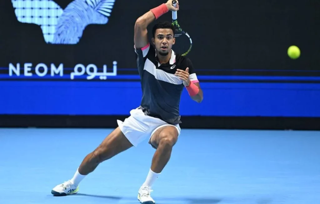 Tennis pro Arthur Fils in mid-swing during a match.