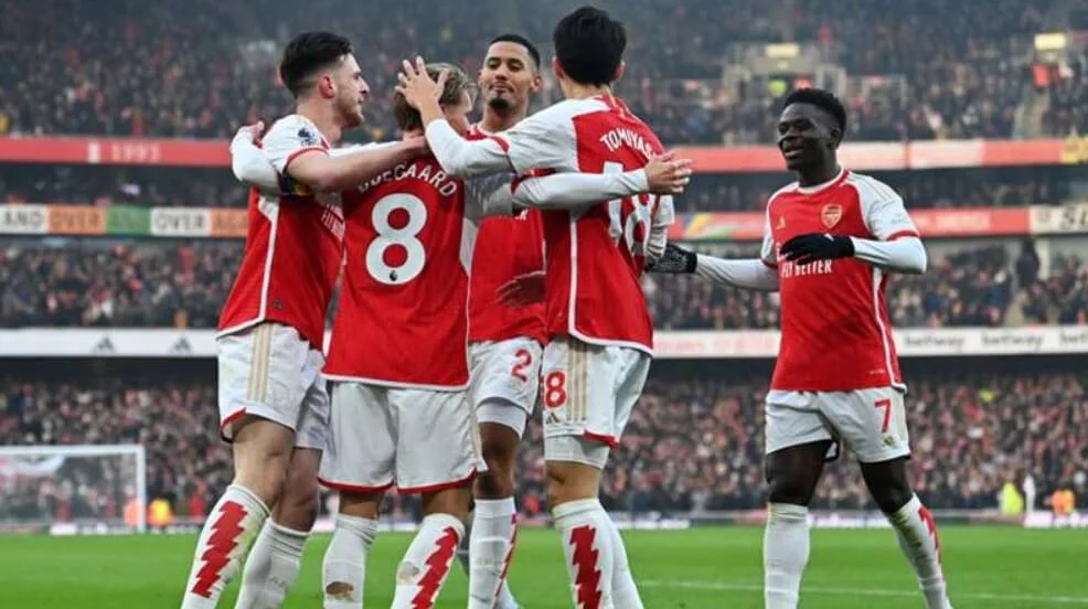 Arsenal athletes expressing joy after scoring a goal.