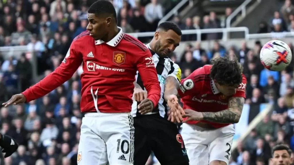 Intense aerial battle between Newcastle and Man Utd players in Premier League match.